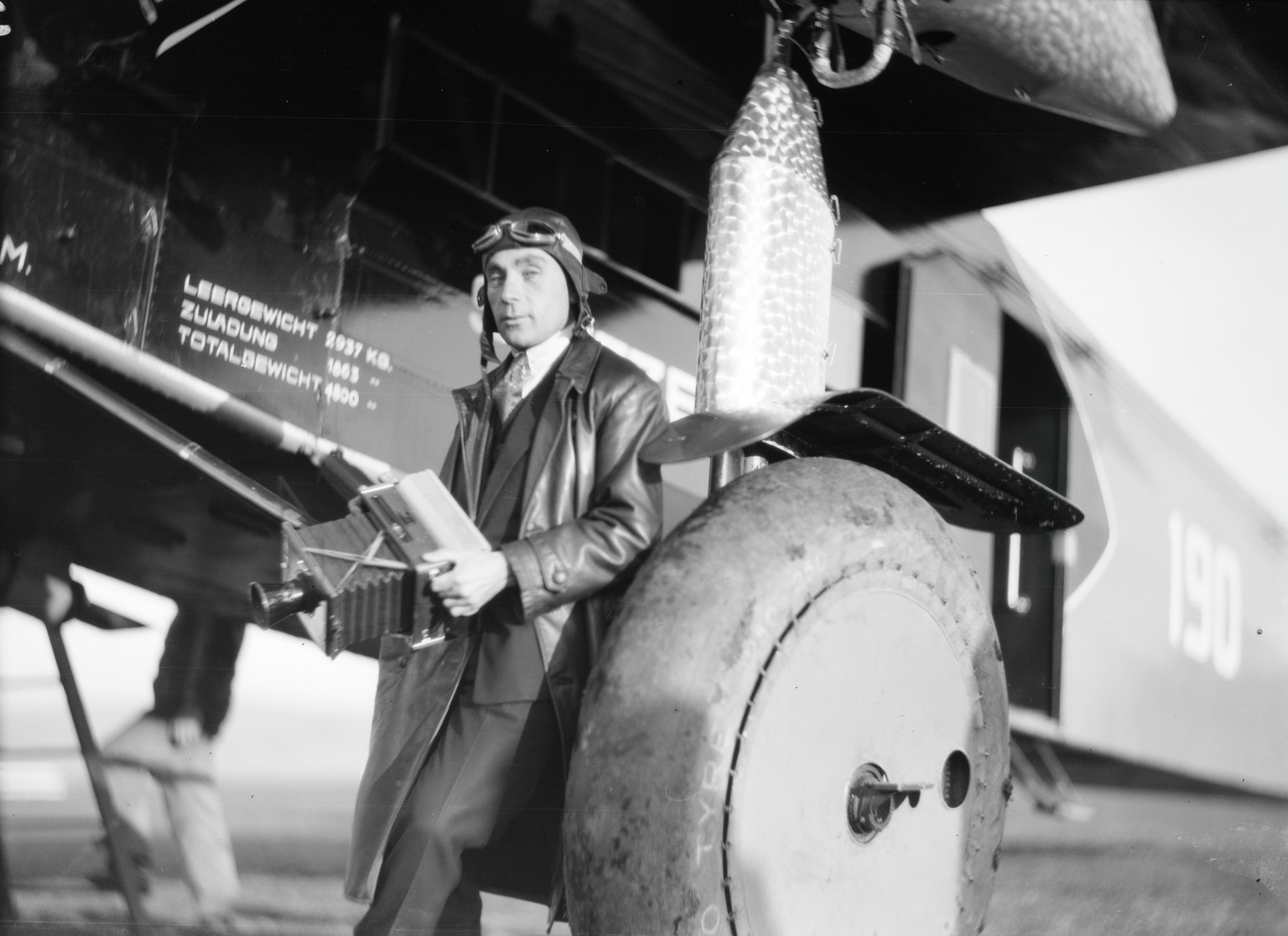 Walter Mittelholzer posiert während seines Kilimandjaro-Flugs 1929/30 mit der Freihandkamera vor der Fokker F.VIIb-3m.