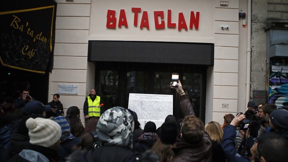 FILE - In this Sunday, Nov. 13, 2016 file photo, onlookers take pictures with their phone in front of the Bataclan concert hall in Paris, France, after a ceremony held for the victims of 2015&#039;s P ...