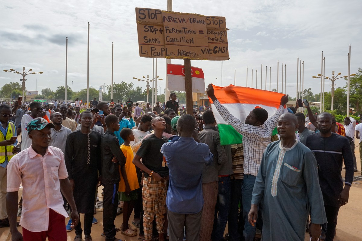 epa10788514 Supporters of the military display a sign that reads 'Stop Areva/Orano, Get out', during a rally in Niamey, Niger, 06 August 2023, (issued 07 August 2023). Thousands of pro-junta ...