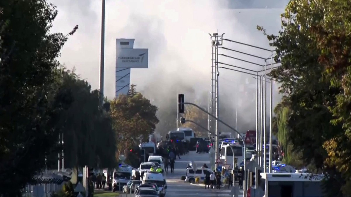 Smoke raises as emergency rescue teams and police officers attend outside Turkish Aerospace Industries Inc. on the outskirts of Ankara, Turkey, Wednesday, Oct. 23, 2024. (IHA via AP)