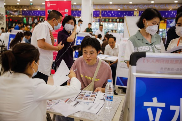 epa10755202 (31/17) Zhang Siyuan (C) interacts with an employer during a job fair in Beijing, China, June 9, 2023. Zhang Siyuan, 24, a graduate of art and painting from Qinhuangdao city in Hebei...