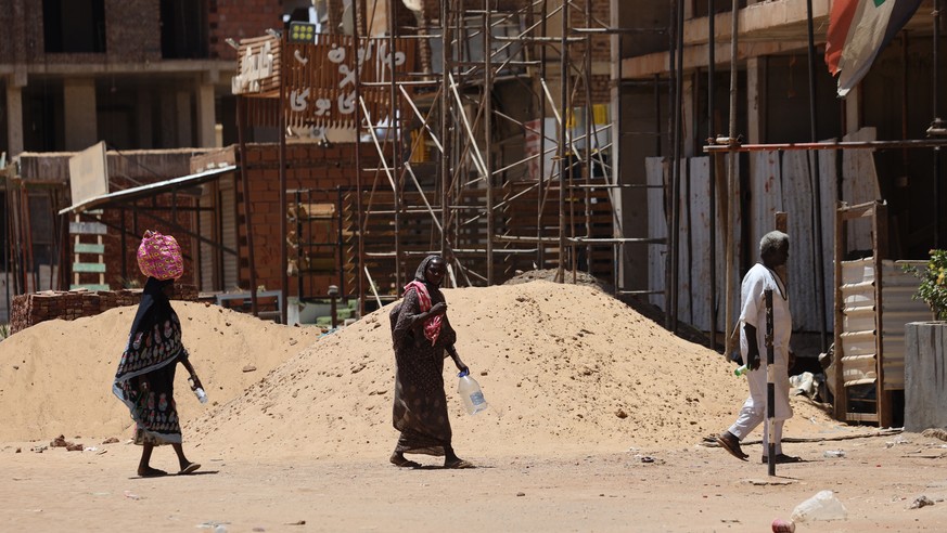 epa10578770 Sudanese people walk with empty bottles and jerrycans while looking for drinking water after supplies were affected due to the ongoing fighting between Sudanese army and paramilitaries of  ...