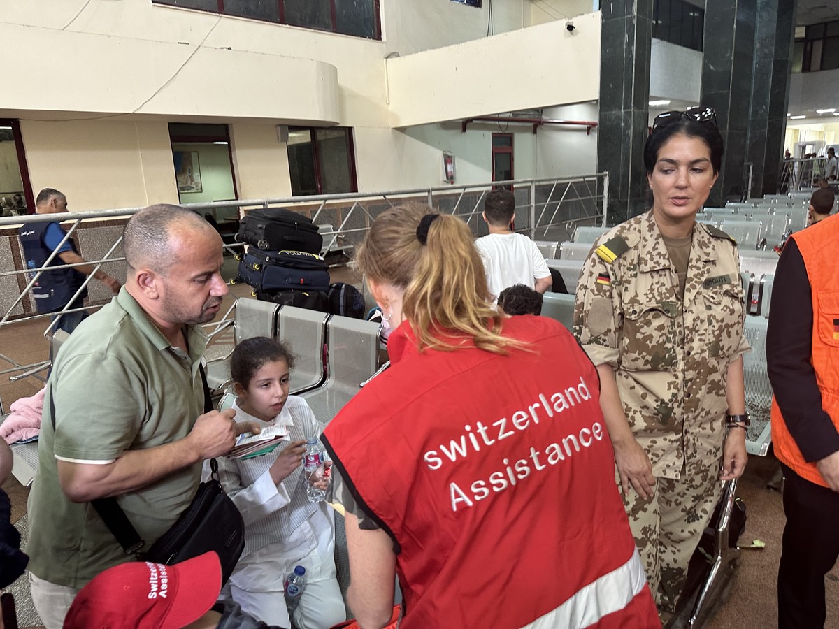 epa10954347 Several foreign nationals wait at the Egyptian side of the border after passing the Rafah border crossing between the Gaza Strip and Egypt, in Rafah, Egypt, 02 November 2023. As per the ag ...
