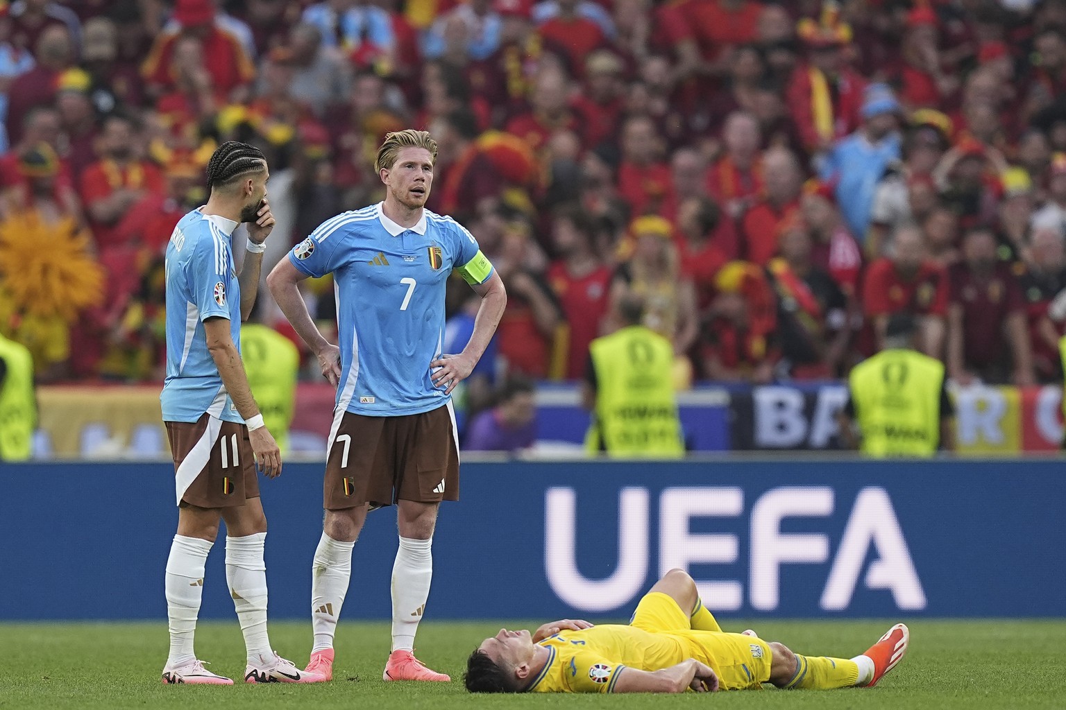 Belgium&#039;s Kevin De Bruyne, center, and Yannick Carrasco, left, gather next to Ukraine&#039;s Oleksandr Tymchyk at the end of a Group E match between Ukraine and Belgium at the Euro 2024 soccer to ...