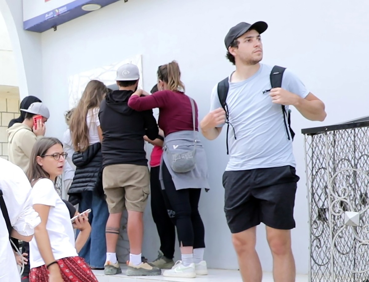 epa12630833 Foreign tourists gather outside the closed office of Yemenia Airways on the island of Socotra, Yemen, 06 January 2026. Hundreds of foreign tourists have been left stranded on Socotra, in t ...