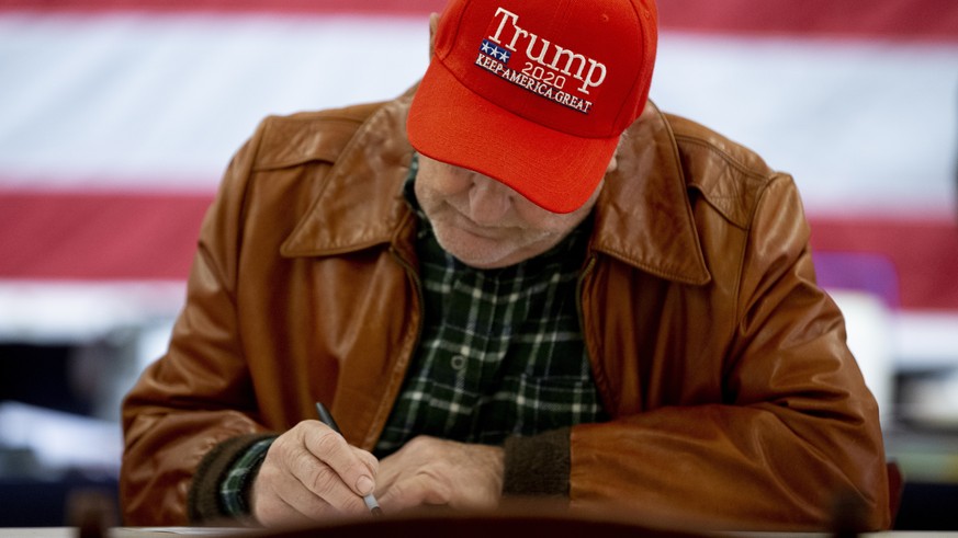epa10293645 A Trump supporter votes with a write-in ballot on election day at a polling location at the Old Stone School in Hillsboro, Virginia, USA, 08 November 2022. The US midterm elections are hel ...