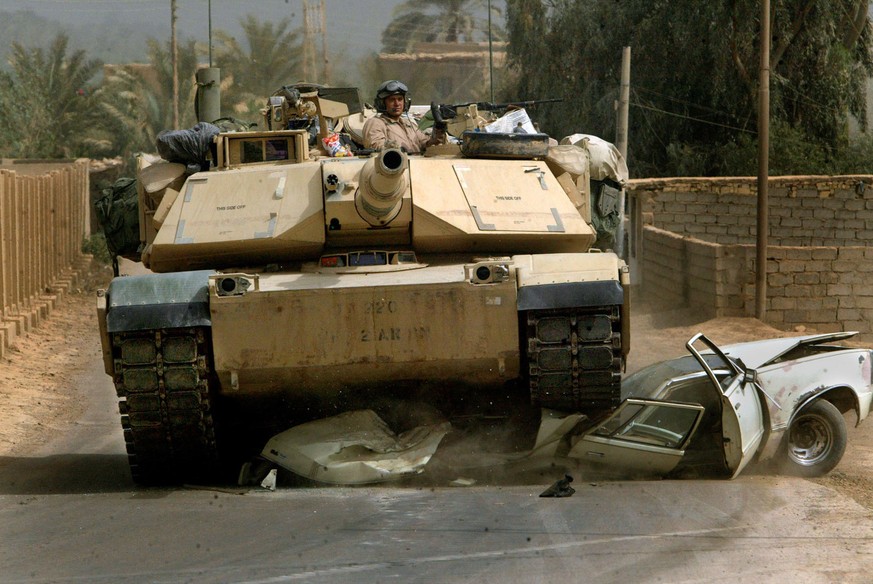 U.S. Army units from 3rd Infantry Division based in Fort Benning Ga., advance on northern Baghdad, Sunday, April 6, 2003. An M1-A1 Abrams drives over a disabled vehicle near the Tigris River. (KEYSTON ...