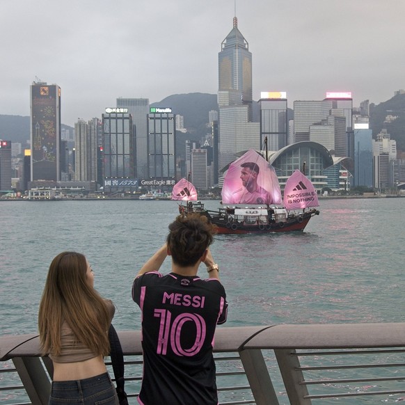 HONG KONG, CHINA - FEBRUARY 03: Fans take photos as a sailing ship bearing a portrait of Inter Miami CF s Argentine forward Lionel Messi sails across the Victoria Harbour on February 3, 2024 in Hong K ...