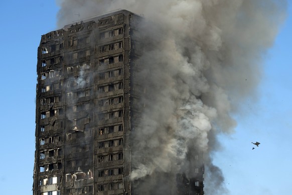 epa06027179 Smoke rises from the fire at the Grenfell Tower apartment block in North Kensington, London, Britain, 14 June 2017. According to the London Fire Brigade, 40 fire engines and 200 firefighte ...