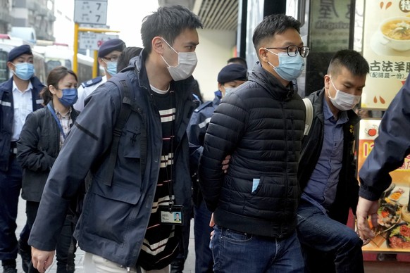 Editor of &quot;Stand News&quot; Patrick Lam, center, is arrested by police officers in Hong Kong, Wednesday, Dec. 29, 2021. Hong Kong police say they have arrested seveal current and former staff mem ...