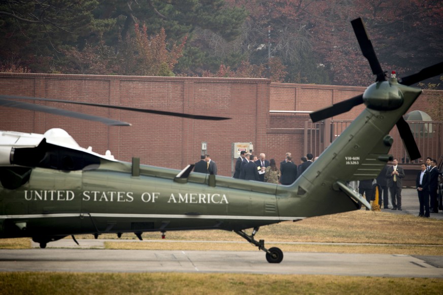 President Donald Trump&#039;s Chief of Staff John Kelly, at center, checks his watch as administration staff try to wait out a bad weather call at U.S. Army Garrison Yongsan, Seoul, South Korea, Wedne ...