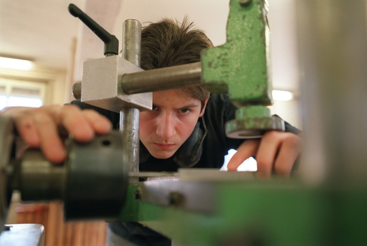 Ein Lehrling bei der Arbeit an der Maschine im Unterricht an der Abteilung Lehrwerkstaette fuer Moebelschreiner an der baugewerblichen Berufsschule Zuerich, aufgenommen am 4. Maerz 2003. (KEYSTONE/Gae ...