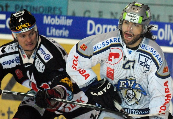 Der Zuger Josh Holden, rechts, und der Fribourger Shawn Heins, links, kaempfen um den Puck, beim Eishockey Meisterschaftsspiel der National League A zwischen dem HC Fribourg-Gotteron und dem EV Zug am ...