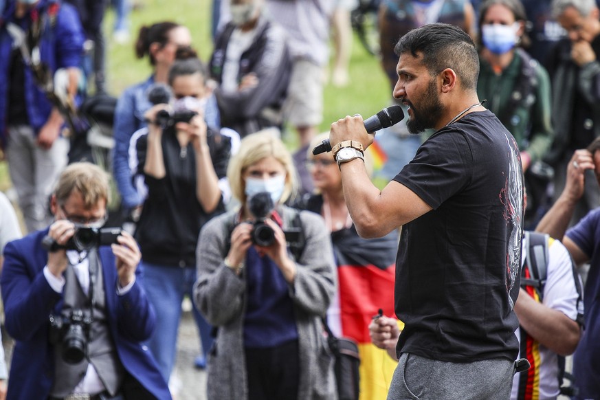 epa08540648 German vegan chef Attila Hildmann, speaks to his followers during an anti-restrictions protest at the Lustgarten park in Berlin, Germany, 11 July 2020. Hildmann supporters demonstrate main ...