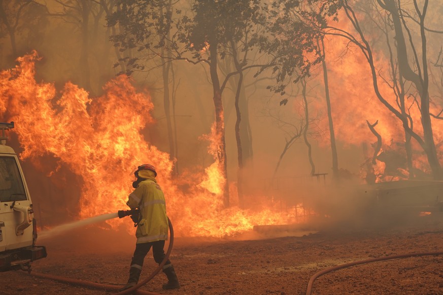 epa08983284 A handout photo made available on 03 February 2021 by Australia's Department of Fire and Emergency Services (DFES) shows firefighters battling the Wooroloo Bushfire, north-west of Perth, A ...