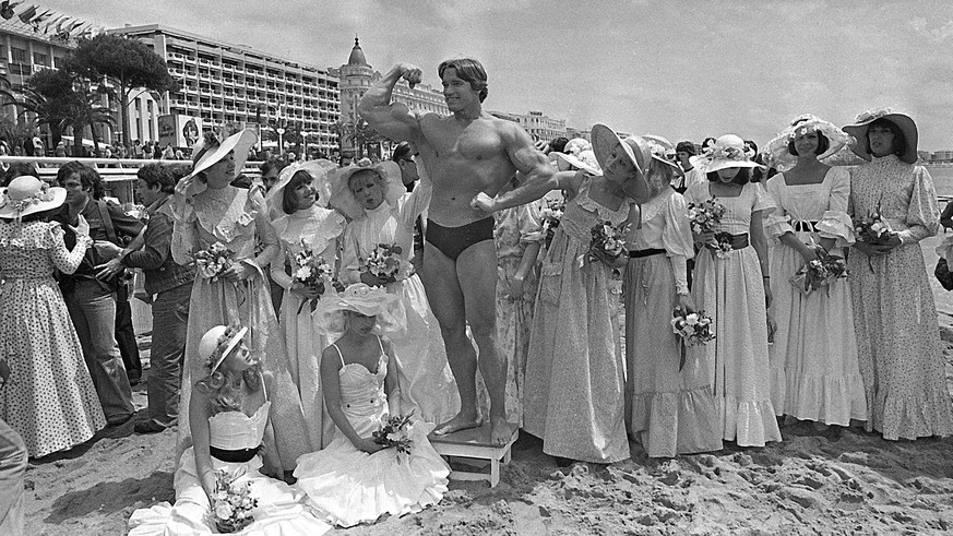In this May 20, 1977 file photo Arnold Schwarzenegger, whose documentary film &quot;Pumping Iron&quot; is to be presented at the Cannes Film Festival, is showing off his body for an appreciative beach ...