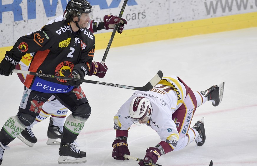 Der Genfer Adam Hasani, rechts, stolpert vor die Fuesse des Berners Beat Gerber, links, im ersten Eishockey Playoff-Viertelfinalspiel der National League zwischen dem SC Bern und dem Geneve Servette H ...