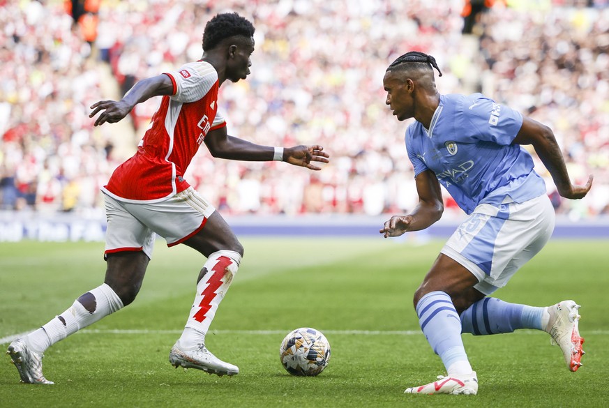 epa10787804 Bukayo Saka (L) of Arsenal in action against Manuel Akanji (R) of Manchester City during the FA Community Shield soccer match between Arsenal London and Manchester City in London, Britain, ...