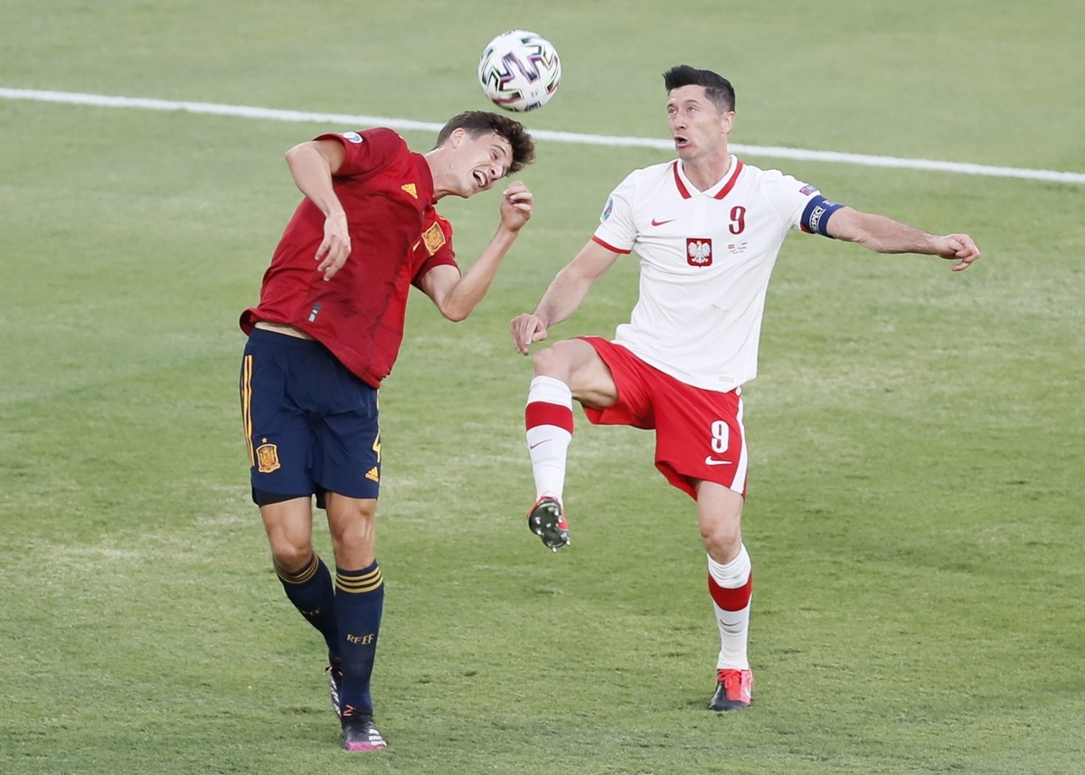Poland's Robert Lewandowski, right, and Spain's Aymeric Laporte challenge for the ball during the Euro 2020 soccer championship group E match between Spain and Poland at Estadio de la Cartuj ...