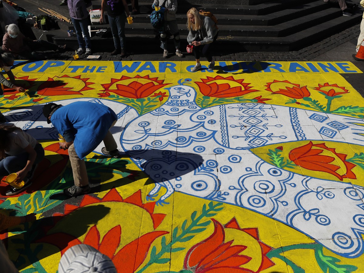 epa09806658 Artist and helpers help recreate an artist piece, 'A Dove Has Spread Her Wings and Asks for Peace' by beloved Ukrainian painter, Maria Prymachenko who had 25 paintings that were  ...
