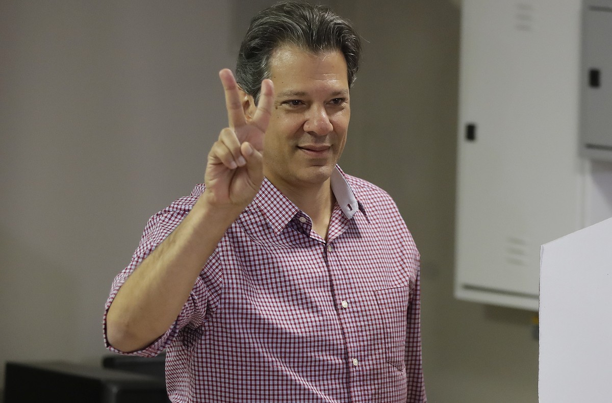 Workers' Party presidential candidate Fernando Haddad, flashes a vee sign after casting his vote, in Sao Paulo, Brazil, Sunday, Oct. 7, 2018. The former Sao Paulo mayor surged into second place a ...
