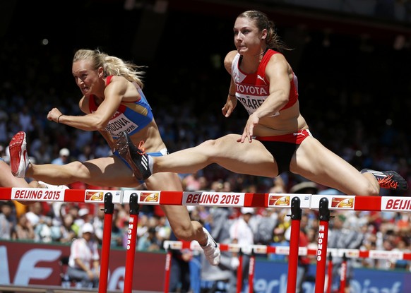 Nina Morozova of Russia (L) and Noemi Zbaren of Switzerland compete in the women&#039;s 100 metres hurdles heats during the 15th IAAF World Championships at the National Stadium in Beijing, China Augu ...