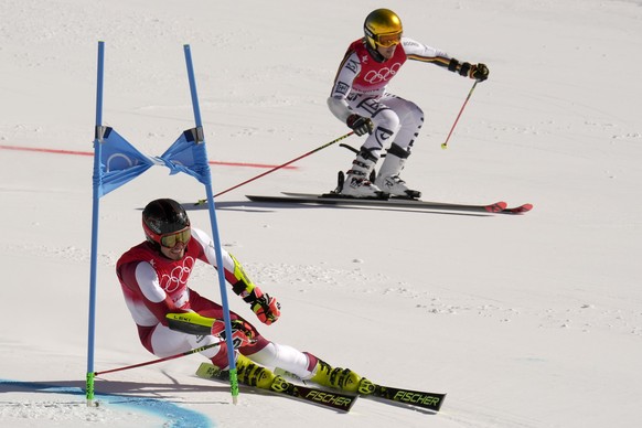 Stefan Brennsteiner of Austria, left, and Julian Rauchfuss of Germany during the gold medal race of the mixed team parallel skiing event at the 2022 Winter Olympics, Sunday, Feb. 20, 2022, in the Yanq ...