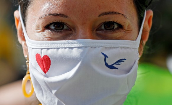 epa08507834 Employees of German carrier Lufthansa stand with a face mask in front of the Lufthansa Aviation Center at the international airport in Frankfurt am Main, Germany, 25 June 2020. The joint v ...