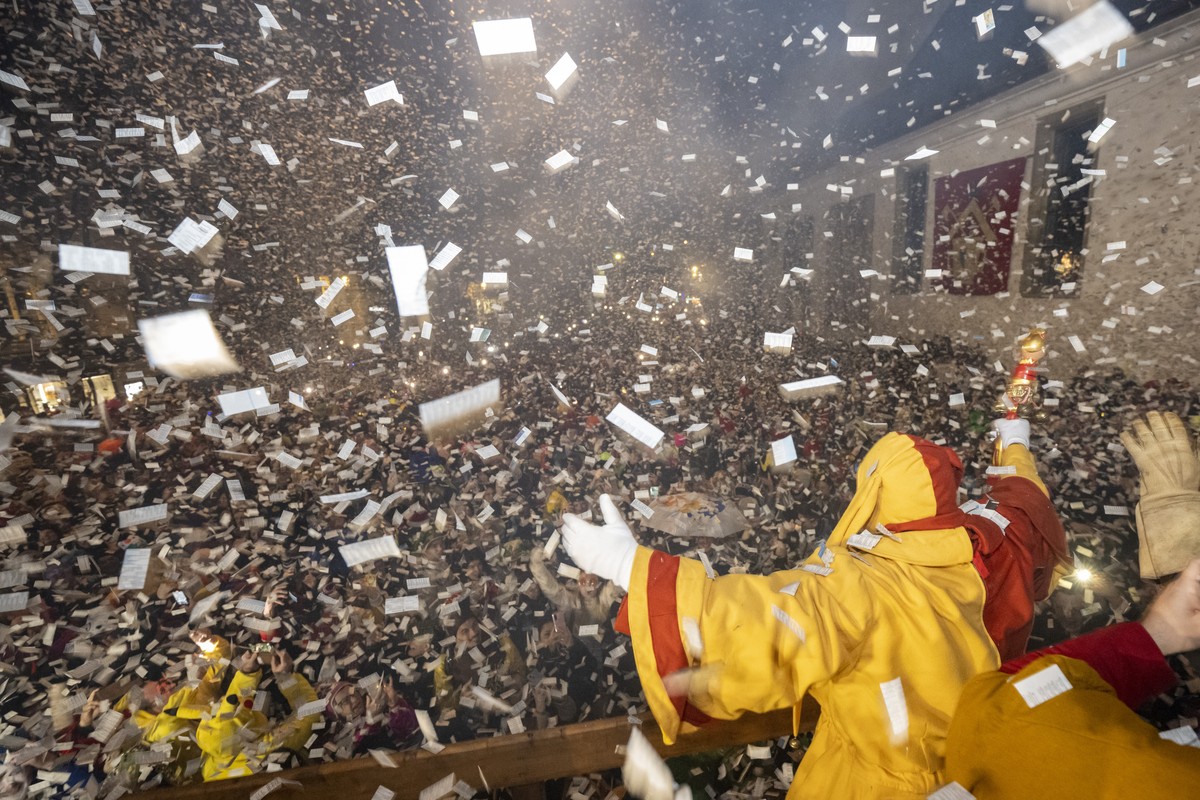 Ein Narr geniesst den 'Foetzeliraege' auf dem Kapellplatz an der Fritschi-Tagwache der Luzerner Fasnacht am Schmutzigen Donnerstag, 8. Februar 2024 in Luzern. Die Luzerner Fasnacht dauert vo ...