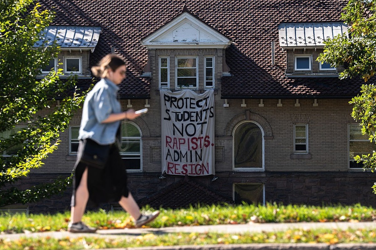 ITHACA, NY - OCTOBER 5: A woman walks past the Stewart Cooperative dormitory at Cornell University in Ithaca, NY, Monday, October 5, 2026,where a banner hangs in response to a lawsuit alleging the 202 ...