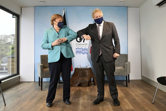 Britain&#039;s Prime Minister Boris Johnson, right, greets German Chancellor Angela Merkel ahead of a bilateral meeting during the G7 summit in Cornwall, England, Saturday June 12, 2021. (Stefan Rouss ...