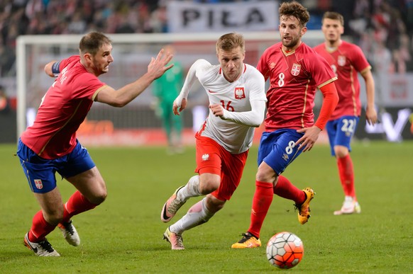 epa05228146 Jakub B=aszczykowski (C) of Poland and Branislav Ivanovic (L) with Miralem Sulejmani (R) of Serbia in action during the football friendly game between Poland and Serbia at Municipal Stadiu ...