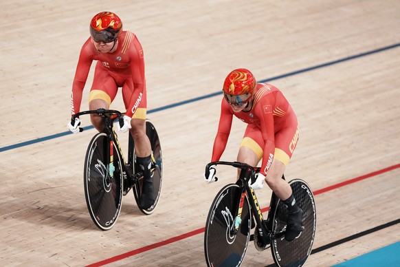 Tianshi Zhong, left, and Shanju Bao of Team China compete during a qualifying heat for track cycling women&#039;s team sprint at the 2020 Summer Olympics, Monday, Aug. 2, 2021, in Izu, Japan. (AP Phot ...