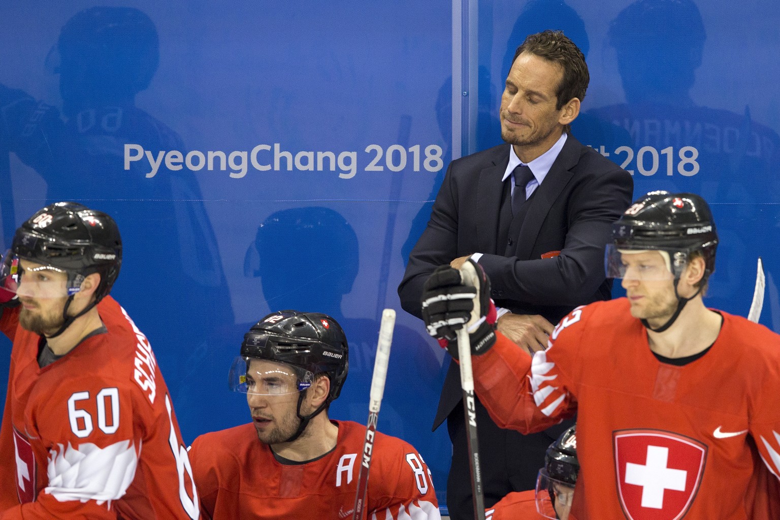 Tristan Scherwey of Switzerland, Simon Moser of Switzerland, Patrick Fischer, head coach of Switzerland, and Simon Bodenmann of Switzerland, from left, react after the men ice hockey play-off qualific ...