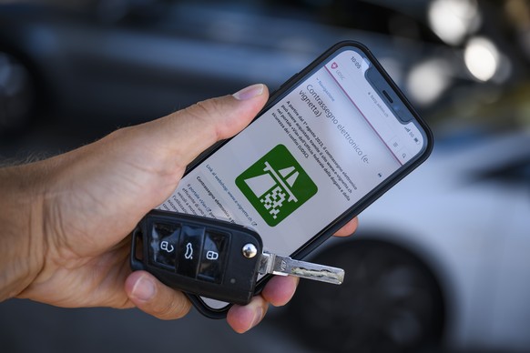 Une personne regarde sur son smartphone le site de la Confederation permettant d&#039;acheter une e-vignette le jeudi 10 aout a Locarno. (KEYSTONE/Jean-Christophe Bott)