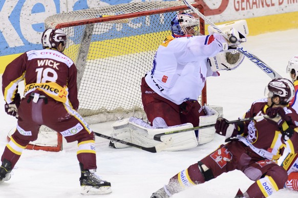 Le gardien Zurichois, Martin Gerber, centre, a la lutte pour le puck avec deux joueurs Genevois, Jeremy Wick, gauche, et Arnaud Jacquemet, droite, lors du match du championnat suisse de hockey sur gla ...