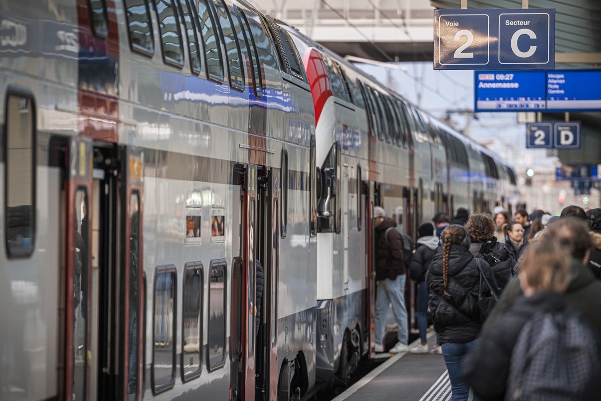 Des voyageurs entrent dans un train ce lundi 9 decembre 2024 a la gare CFF de Renens. Le nouvel horaire CFF 2025 entrera en vigueur le dimanche 15 decembre. (KEYSTONE/Valentin Flauraud)