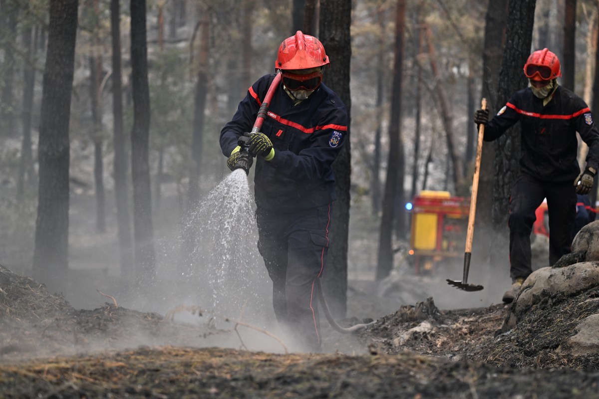 A firefighter sprays water after a wildfire in the region of the Fontainebleau forest, south of Paris, France, Tuesday, July 14, 2026. (AP Photo/Emma Da Silva)
France Wildfires