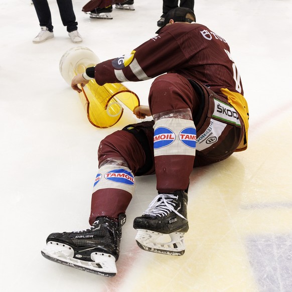 Geneve-Servette&#039;s defender Marco Maurer falls with the trophy of Swiss Champion after winning by 4:1 the seventh and final leg of the ice hockey National League Swiss Championship final playoff g ...