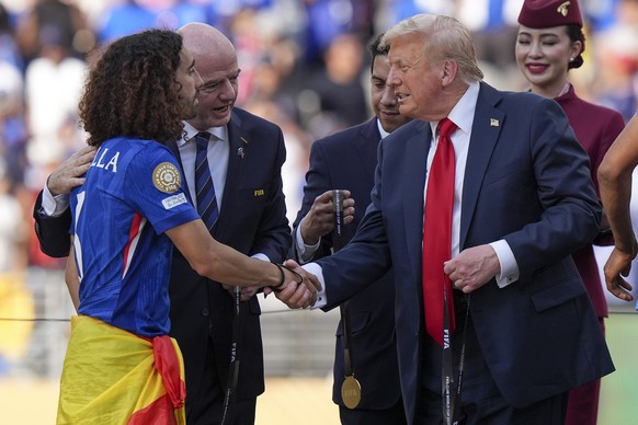 President Donald Trump, right, greets Chelsea&#039;s Marc Cucurella during the trophy ceremony after the Club World Cup final soccer match between Paris Saint-Germain and Chelsea in East Rutherford, N ...