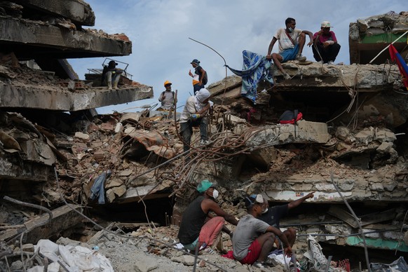 People stand on a collapsed building by the earthquakes in La Guaira, Venezuela, Thursday, July 23, 2026. (AP Photo/Ariana Cubillos)
Venezuela Earthquake