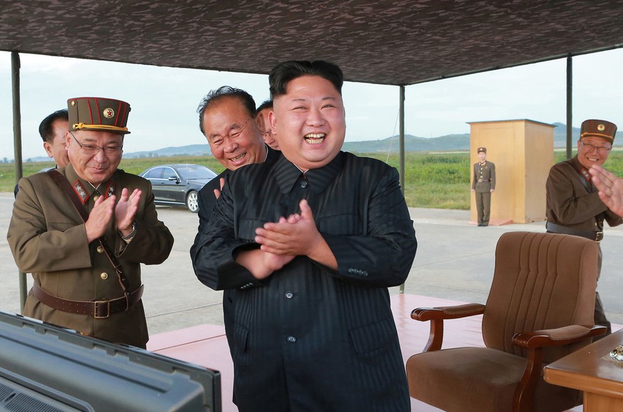 In this undated file photo distributed on Saturday, Sept. 16, 2017, by the North Korean government, North Korean leader Kim Jong Un, center, celebrates what was said to be the test launch of an interm ...