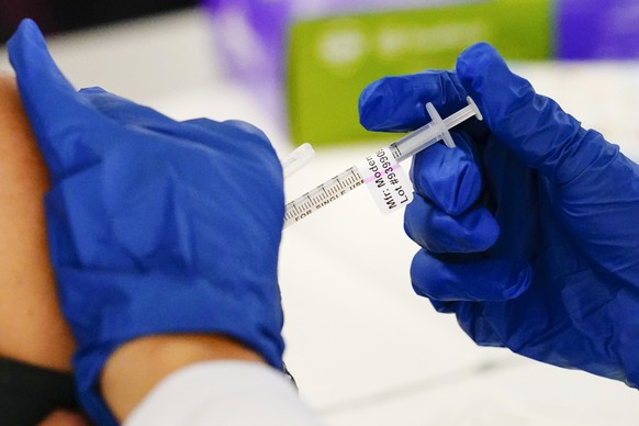 FILE - A health worker administers a dose of a Moderna COVID-19 vaccine during a vaccination clinic in Norristown, Pa. on Dec. 7, 2021. In a reversal for President Joe Biden, a federal appeals court i ...