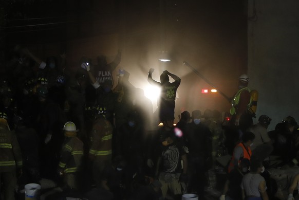 epa06214730 Rescue workers and civilians try to recover living people from collapsed buildings following a 7.1 magnitude earthquake, in Mexico City, Mexico, 19 September 2017. At least 139 people died ...