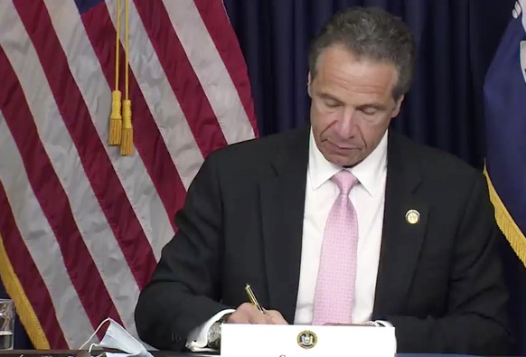 In this photo made from video provided by the office of New York Governor Andrew M. Cuomo, Gov. Cuomo, signs into law, Friday, June 12, 2020, in New York, a sweeping package of police accountability m ...