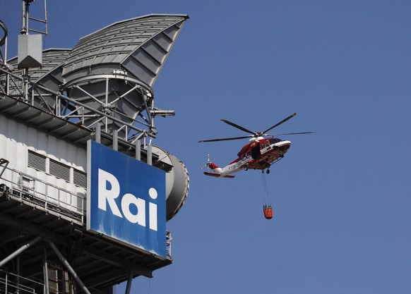 epa11512552 A firefighting helicopter flies near a large fire that broke out near the Judicial City of Piazzale Clodio in Rome, Italy, 31 July 2024, with a high column of smoke having risen and being  ...