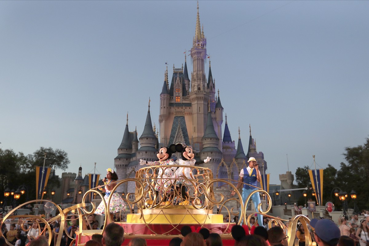 FILE - Mickey and Minnie Mouse perform during a parade as they pass by the Cinderella Castle at the Magic Kingdom theme park at Walt Disney World in Lake Buena Vista, Fla., on Jan. 15, 2020. After app ...