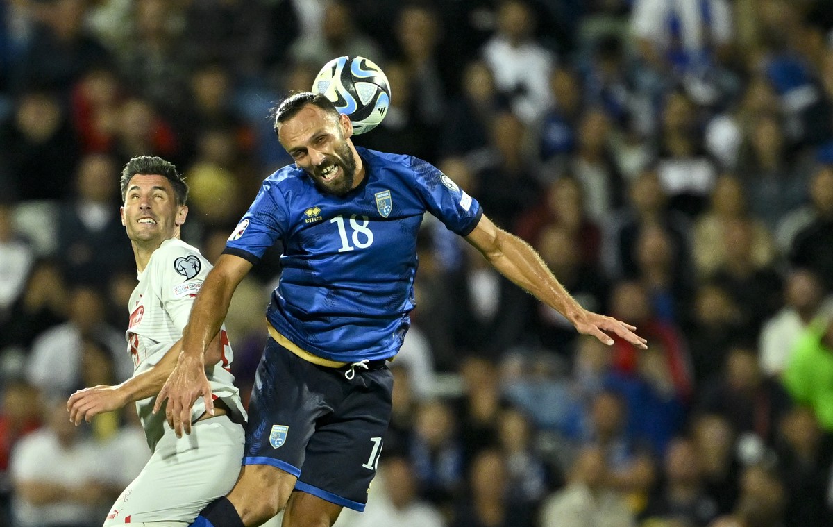 Switzerland's defender Fabian Schaer, left, fights for the ball with Kosovo's forward Vedat Muriqi, right, during the UEFA Euro 2024 qualifying group I soccer match between Kosovo and Switze ...