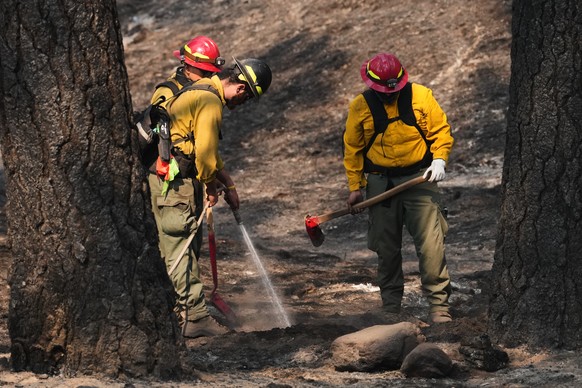 A crew does mop-up work in a burned area of Wyakin Park after a wildfire hit the northern part of Spokane, Wash., Tuesday, Aug. 4, 2026. (AP Photo/Lindsey Wasson)
Western Wildfires