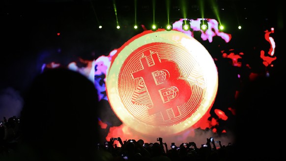 epaselect epa09595075 A bitcoin icon is diplayed during President Nayib Bukele&#039;s announcement about the bitcoin city project that will work in eastern El Salvador, in Santa Maria Mizata, El Salva ...